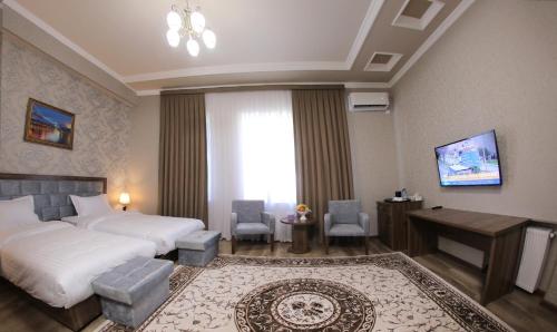 a hotel room with a bed and a table and chairs at ARK BILLUR HALAL Hotel in Tashkent
