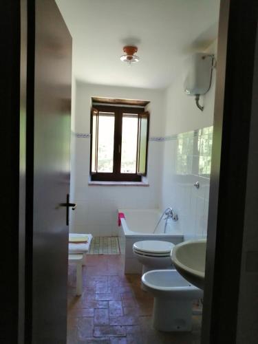 a bathroom with three toilets and a tub and a window at Agriturismo Il Cornalino in Castel Viscardo