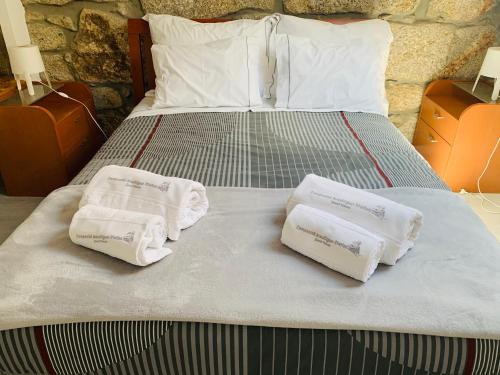 a bed with two towels on top of it at Campanhã Boutique Station in Porto