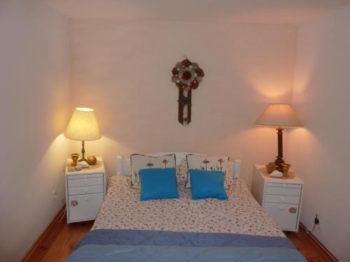 1 dormitorio con 1 cama con almohadas azules y 2 lámparas en KOWALÓWKA, en Mirsk