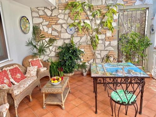 a patio with a table and chairs and a stone wall at Gli Archi in Anacapri