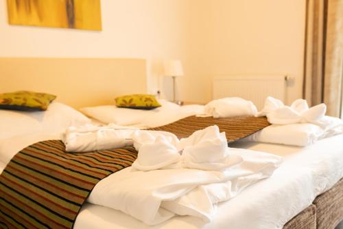 three beds in a room with white sheets at Hotel-Restaurant Liebnitzmühle in Raabs an der Thaya