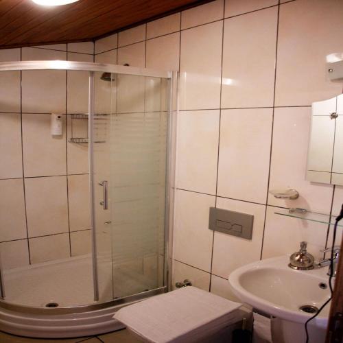 a bathroom with a shower and a sink at Limon Otel Pansiyon 2 in Akyaka