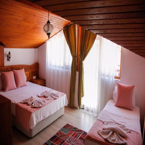 a bedroom with two beds and a window at Limon Otel Pansiyon 2 in Akyaka