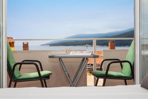 a table and two chairs on a balcony with a view at zdenka in Rabac