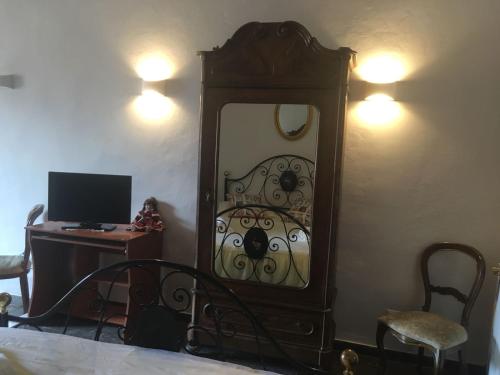 een slaapkamer met een spiegel en een bureau met een computer bij Via ROMA in Montevarchi