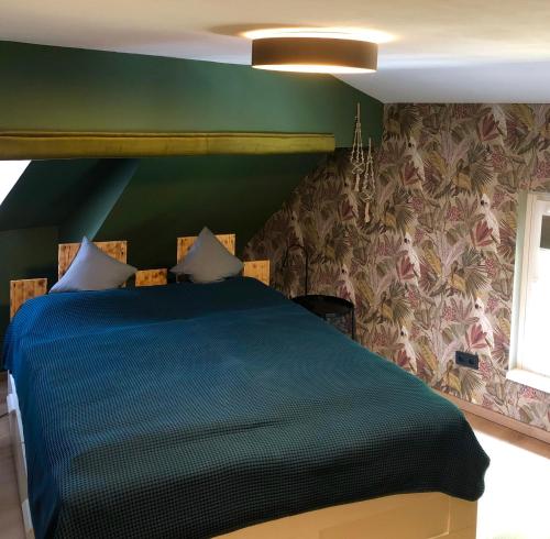a bedroom with a blue bed with a green wall at Paradiesje in Leer