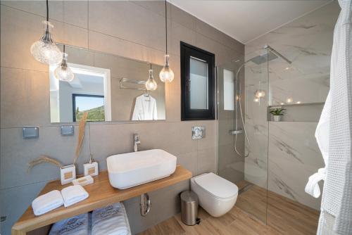 a bathroom with a sink and a shower at Diosas Luxury Villas in Pilaroú