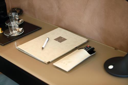 a pen sitting on top of a desk with a notebook at Hotel Bell'arrivo by Dori in Peschiera del Garda