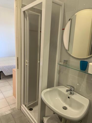 Un baño con lavabo, espejo y ducha. en Baia dei Gabbiani, en San Lorenzo al Mare