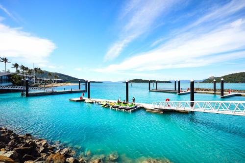 a dock in the water with people sitting on it at Daydream Island Resort in Daydream Island