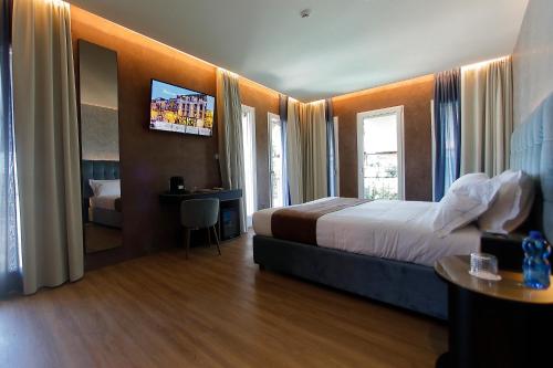 a hotel room with a bed and a television at Hotel Bell'arrivo by Dori in Peschiera del Garda