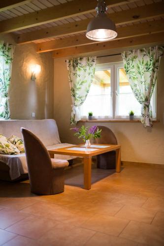 a living room with a table and a couch at Domki nad stawem. in Polańczyk