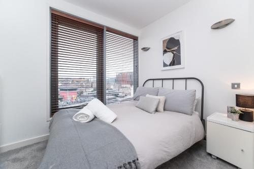 ニューカッスル・アポン・タインにあるNewcastle Penthouse - Sleeps 8 - City Centre - Free Parking - City Viewsのベッドルーム(大きな窓、白いベッド付)
