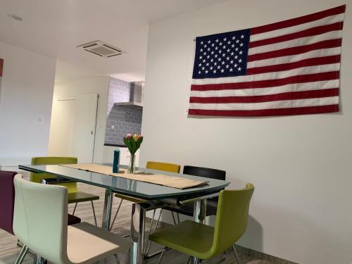 a table and chairs with an american flag on the wall at Yacht Club Apartamenty in Radzyń