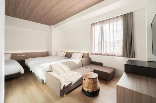 広島市にあるネストホテル広島駅前のベッドとソファのあるホテルの部屋