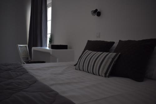 a bedroom with a bed with two pillows and a window at Island Concept Chania in Agia Marina Nea Kydonias