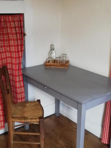 a table in a room with a wooden chair and a table sidx sidx at Le domaine des 3 marmottes Chambres d' hôtes in Cierp