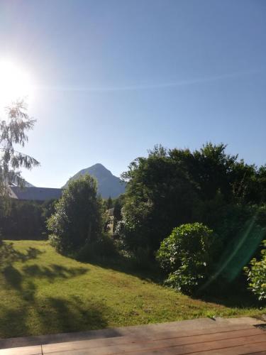 a view of a field with a mountain in the background at Le domaine des 3 marmottes Chambres d' hôtes in Cierp