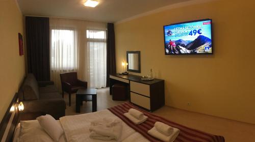 a hotel room with a bed and a television on the wall at Apartmán Bešeňová 289 in Bešeňová
