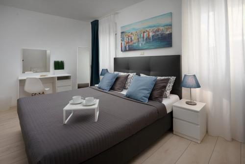 1 dormitorio con 1 cama grande y mesa en Apartments Antons 2, en Pula