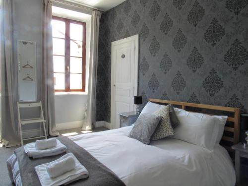 a bedroom with a bed with two towels on it at Les Deux Rives in Cierp