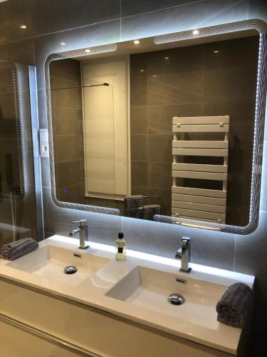 une salle de bain avec un lavabo et un grand miroir dans l'établissement RAMATUELLE SAINT TROPEZ, en front de mer, à Ramatuelle