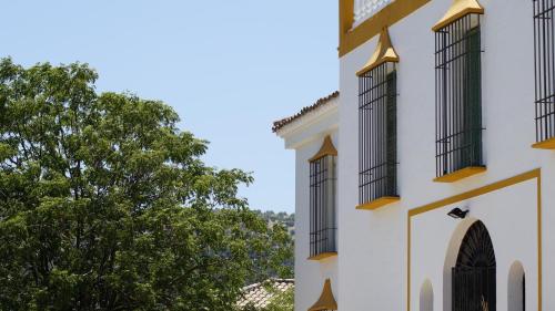 a building with two windows and a tree at Caserio de Iznájar in Iznájar
