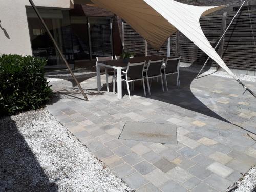 a patio with a table and chairs under a tent at Au Paradis Guesthouse in Waregem