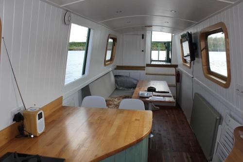 a small room with a table and chairs in a trailer at Waterbeach Boatel in Cambridge
