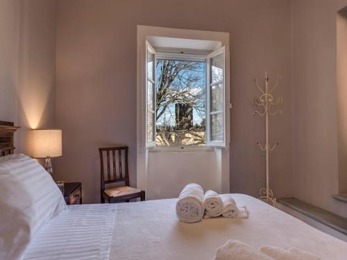 1 dormitorio con 1 cama con toallas y ventana en Agriturismo La Fattoria di Capezzana, en Carmignano