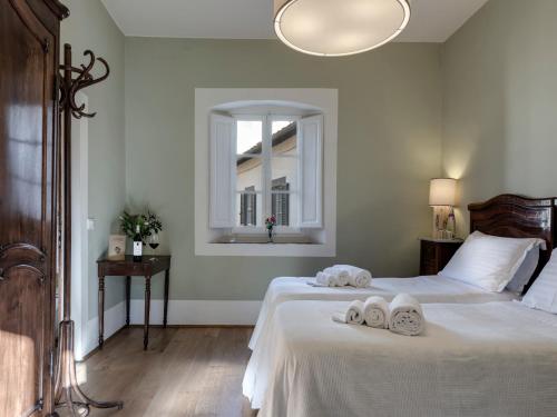 a bedroom with two towels on a bed with a window at Agriturismo La Fattoria di Capezzana in Carmignano