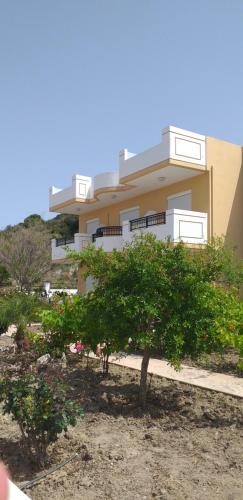 a building with a tree in front of it at Nephele Apartments in Faliraki