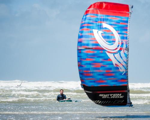 a man on the beach with a sail at Villa les Voiles - Chambres d'hôtes in Wimereux