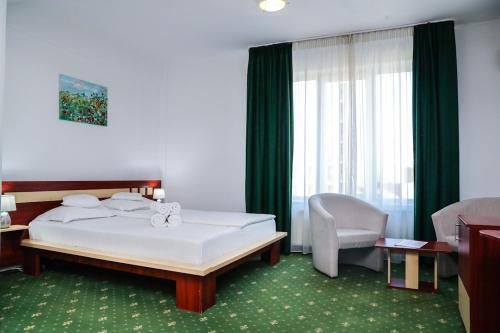 Habitación de hotel con cama y silla en Hotel Pami, en Cluj-Napoca