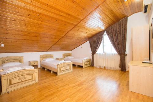 um quarto com 2 camas e um tecto de madeira em Hostel Teplo em Sochi