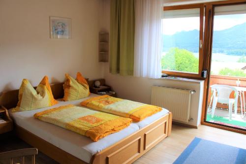 1 Schlafzimmer mit 2 Betten und einem großen Fenster in der Unterkunft Gästehaus Uggowitzer in Drobollach am Faakersee