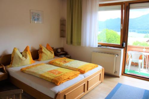 a bedroom with two beds and a large window at Gästehaus Uggowitzer in Drobollach am Faakersee