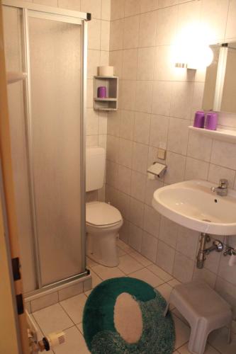 La salle de bains est pourvue d'une douche, de toilettes et d'un lavabo. dans l'établissement Gästehaus Uggowitzer, à Drobollach am Faakersee