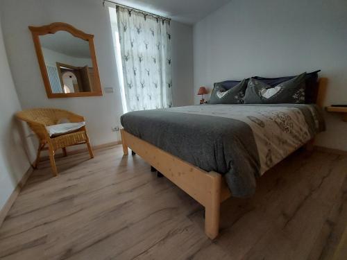 a bedroom with a bed and a mirror and a chair at Casa Rita in Tesero
