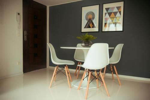 a dining room with a table and white chairs at Zeus Design Loft Apartments in Vienna