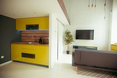 a kitchen with yellow cabinets and a couch in a living room at Zeus Design Loft Apartments in Vienna