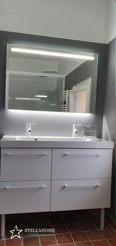 une salle de bain avec un lavabo et un miroir dans l'établissement StellaHome - Sur Les Toits, à Sanary-sur-Mer