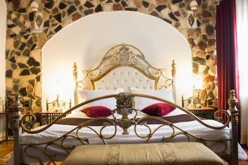 a bedroom with an ornate bed with red pillows at Hunter Prince Castle Hotel in Turda