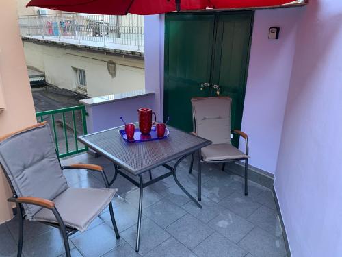 una mesa y sillas en un balcón con sombrilla en Opatija Central Studio Apartment, en Opatija