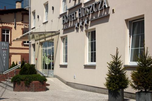 un bâtiment avec un panneau sur son côté dans l'établissement Hotel Huszcza, à Mrągowo