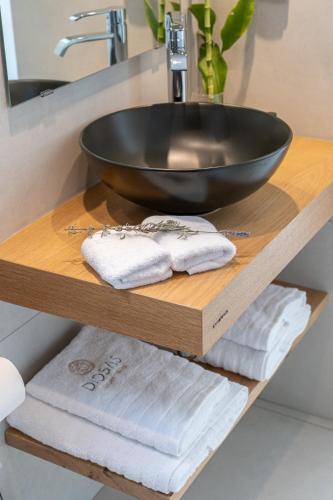 a wooden shelf with a sink and towels on it at Diosas Luxury Villas in Pilaroú