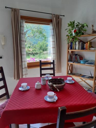 una mesa roja con tazas y platillos. en Il Pesco en Nus