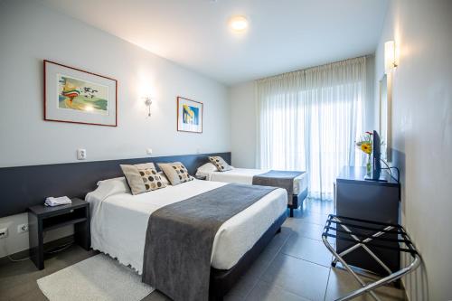 ボリケイメにあるBoutique & Villas Boliqueimeのベッド2台とテレビが備わるホテルルームです。