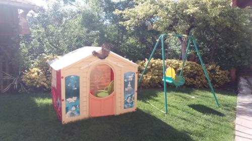 a play house and a swing in the grass at Apartmani Mali Raj Rudnik in Rudnik Kačerski